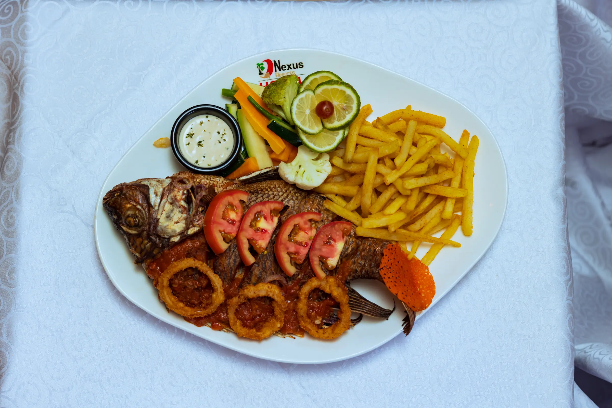 Grilled whole tilapia with chips, salad and dipping sauce